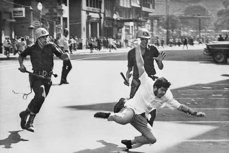 Military police chasing a demonstrator during a crackdown on protests.