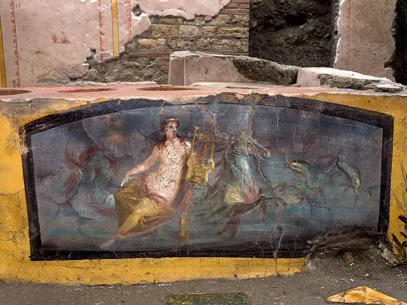 Excavated thermopolium in Pompeii showing the stone counter with painted frescoes and embedded dolia jars
